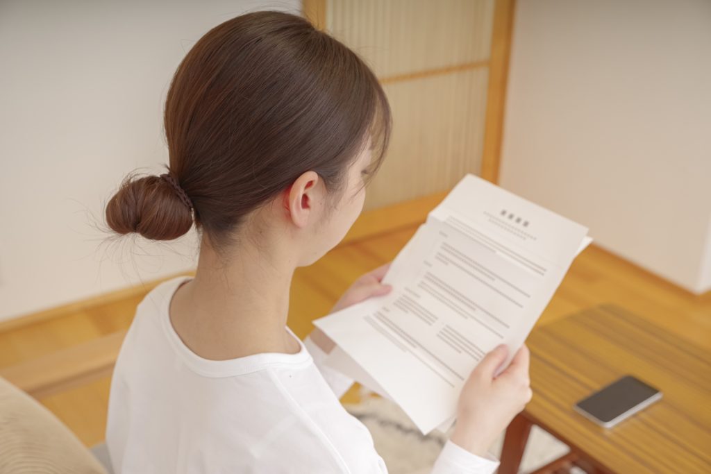 リビングで書類を確認する女性