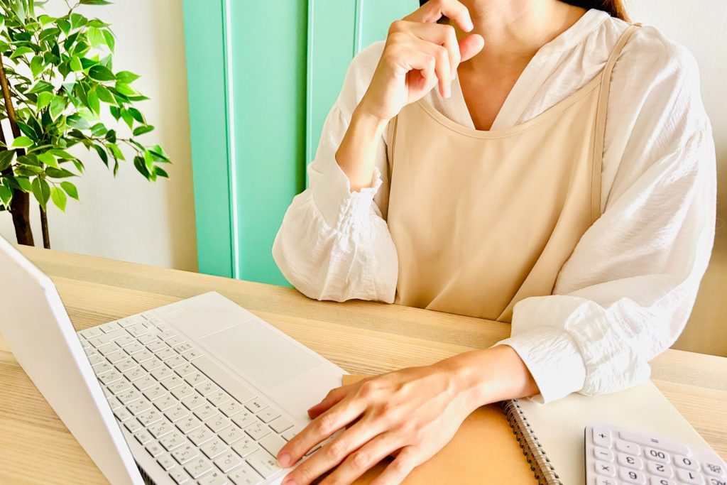 パソコンを見ながら悩む女性