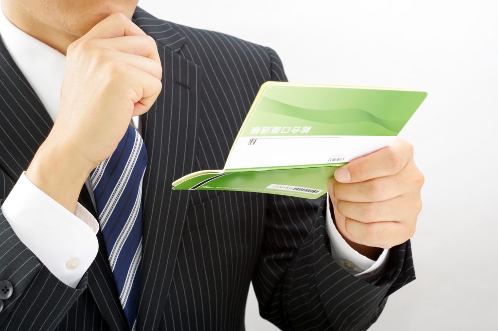 通帳を持つサラリーマン男性