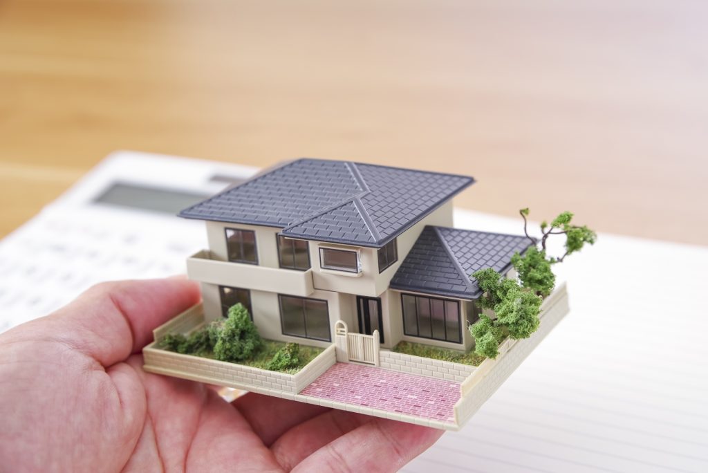 手のひらに乗った家の模型