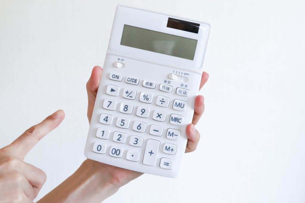 白い電卓を指差す手