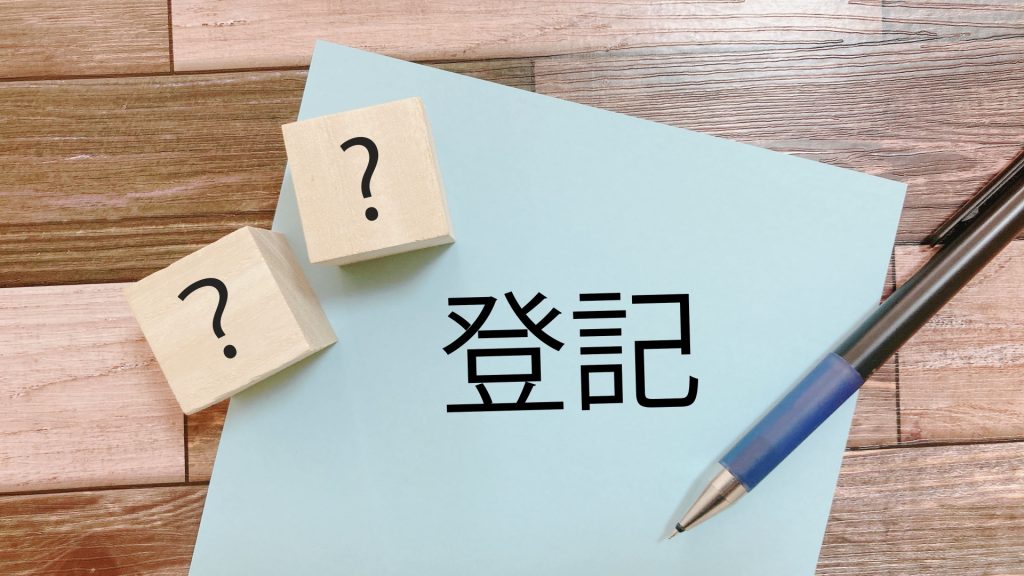 登記と書かれた紙と疑問符