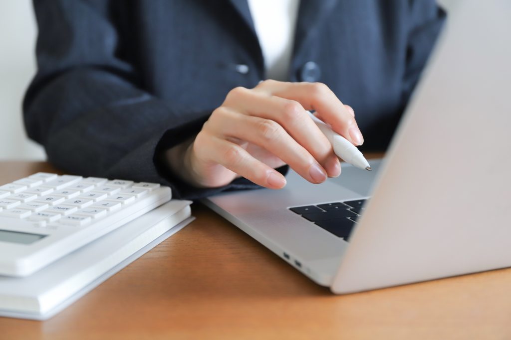 電卓とパソコンで計算する様子