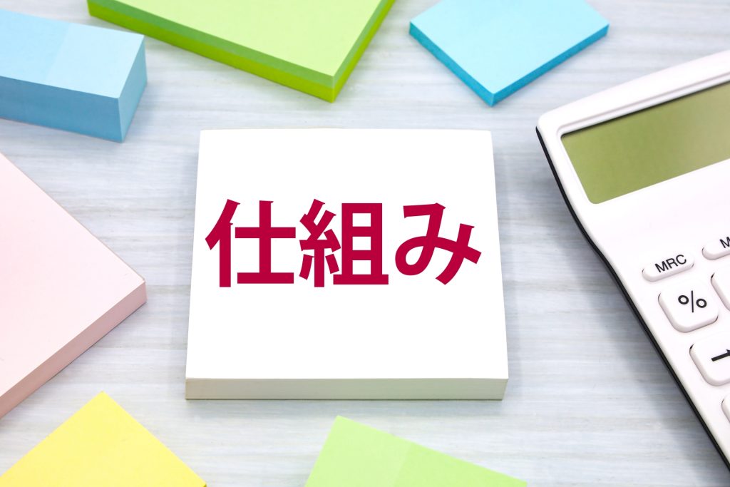 仕組みと書かれたメモと電卓