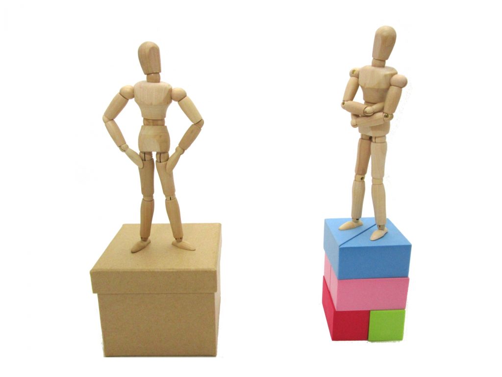 立場の違いを表現した2体の木製人形