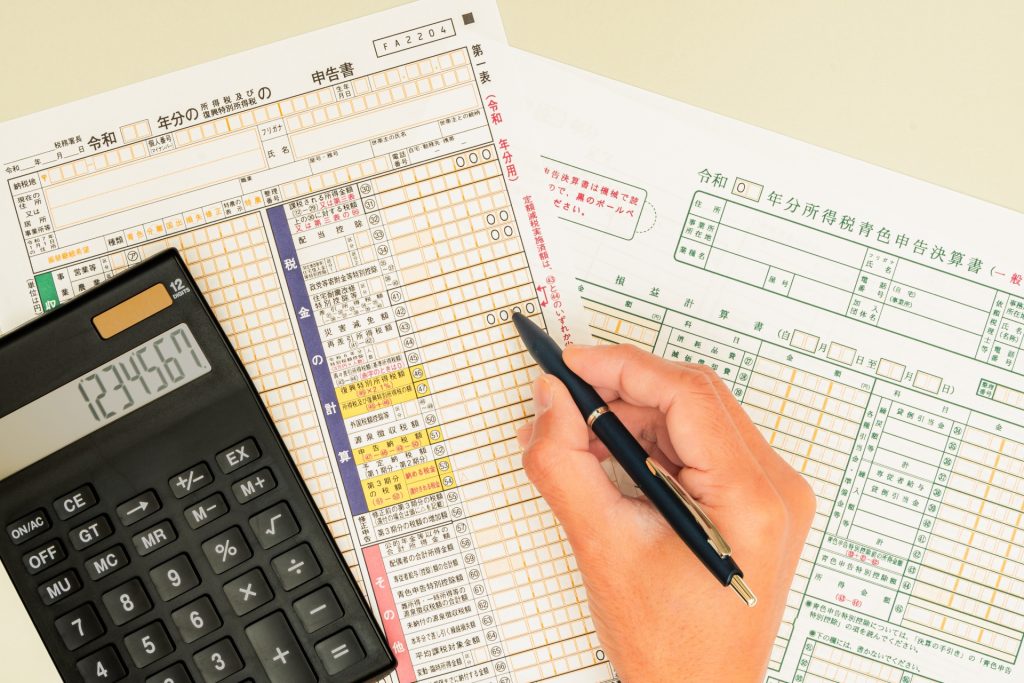 確定申告書に記入する手元と電卓